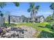 A screened pool is surrounded by lush green grass, and a beautiful palm tree towers over the house at 7529 Winter Shade Dr, Orlando, FL 32822