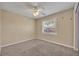 Bedroom features neutral carpet, a ceiling fan, and natural light from the window at 7529 Winter Shade Dr, Orlando, FL 32822