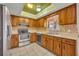 Well-lit kitchen features oak cabinets, tile backsplash, stainless steel appliances, and a window at 7529 Winter Shade Dr, Orlando, FL 32822