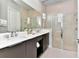 Bathroom featuring double sinks, a large mirror, and a glass-enclosed walk-in shower at 7740 Sandy Ridge Dr # 136, Reunion, FL 34747