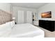 Modern bedroom featuring a tufted headboard, sunset artwork and sleek dark dresser at 7740 Sandy Ridge Dr # 136, Reunion, FL 34747