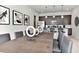 Elegant dining space featuring a wooden table, modern chairs, artwork, and pendant lighting above a kitchen counter at 7740 Sandy Ridge Dr # 136, Reunion, FL 34747