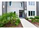 Modern building exterior featuring a walkway, well manicured landscaping, and a clearly visible address at 7740 Sandy Ridge Dr # 136, Reunion, FL 34747