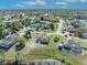 Aerial view showcases the home's location in a lush, green neighborhood near a lake, ideal for families at 789 Kangaroo Ct, Deltona, FL 32738