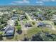 Wide aerial perspective of a residential neighborhood showcasing beautiful homes and scenic natural surroundings with a lake at 789 Kangaroo Ct, Deltona, FL 32738