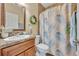 Bathroom featuring a granite countertop vanity, a toilet, and a shower with a tropical curtain at 789 Kangaroo Ct, Deltona, FL 32738