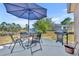 Outdoor patio features a dining set, umbrella, grill, and scenic waterfront views for relaxing outdoor enjoyment at 789 Kangaroo Ct, Deltona, FL 32738