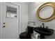 Elegant powder room featuring a black pedestal sink, toilet, and stylish gold-trimmed mirror at 8905 South Bay Dr, Orlando, FL 32819