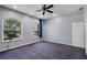 The bedroom features an arched window with a lush view and patterned carpet flooring at 8905 South Bay Dr, Orlando, FL 32819