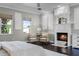 The main bedroom offers dark wood flooring, a fireplace, and serene seating beneath the window at 8905 South Bay Dr, Orlando, FL 32819