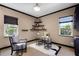 Bright office space featuring a modern desk, chair, stylish shelving, and natural light from two windows at 8905 South Bay Dr, Orlando, FL 32819