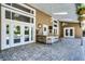 Covered outdoor patio featuring a wet bar with counter seating, ceiling fans and stylish stone flooring at 8905 South Bay Dr, Orlando, FL 32819