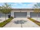 Modern townhouse featuring a two-car garage, a concrete driveway, and fresh landscaping at 9732 Brown Burrow St, Orlando, FL 32829