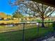 This backyard view features a serene pond reflecting blue skies, lush greenery, and mature trees, perfect for relaxation at 9843 Tivoli Villa Dr, Orlando, FL 32829