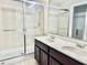 This bathroom boasts a glass enclosed shower and a double sink vanity offering both style and functionality at 9843 Tivoli Villa Dr, Orlando, FL 32829