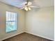 Bright, carpeted bedroom with a ceiling fan and a window overlooking the neighborhood at 9843 Tivoli Villa Dr, Orlando, FL 32829