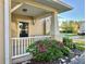 Inviting porch with white railing, decorative plants, and a view of the peaceful neighborhood street at 9843 Tivoli Villa Dr, Orlando, FL 32829