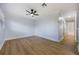 This room features light-colored walls, wood floors, ceiling fan, and view to hallway at 10526 Fernando St, Orlando, FL 32825