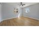 This bedroom features light-colored walls, wood floors, a ceiling fan, and two windows at 10526 Fernando St, Orlando, FL 32825