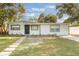 Charming single-story home with a well-manicured front yard, stepping stone pathway and green trim at 10526 Fernando St, Orlando, FL 32825