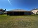 Expansive backyard featuring a screened-in lanai and lush green lawn, perfect for outdoor living and entertaining at 10912 Smokey Ridge Ct, Clermont, FL 34711