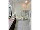 Bright bathroom featuring a glass shower, soaking tub, and double vanity with granite counters on marble floors at 12526 Ringwood Ave, Orlando, FL 32837