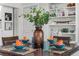Well-set dining table with place settings, flowers, and views of built in shelving at 134 Roberta Rd, Ormond Beach, FL 32176
