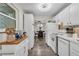 Bright kitchen with white cabinetry, stainless sink, tile backsplash, and a view into the dining area at 134 Roberta Rd, Ormond Beach, FL 32176
