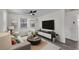 Cozy living room featuring a comfortable sofa, modern furniture, and a mounted TV at 134 Roberta Rd, Ormond Beach, FL 32176