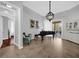 Living room showcasing tile floors, gray walls, grand piano, chandelier, and sliding doors to outside at 1415 Crocus Ct, Longwood, FL 32750