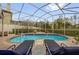 Relaxing pool with lounge chairs inside a screened enclosure and brick-paved surround at 1415 Crocus Ct, Longwood, FL 32750