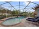 Sparkling pool inside a screened enclosure with brick-paved surround and lush privacy landscaping at 1415 Crocus Ct, Longwood, FL 32750