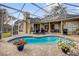 Spacious outdoor pool area with a screened enclosure, plenty of seating, and lush landscaping at 1415 Crocus Ct, Longwood, FL 32750