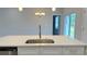 Close-up of a kitchen island with a stainless steel sink and quartz countertops, offering a view of the dining area at 14222 Sw 48Th Ave Rd, Ocala, FL 34473
