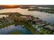 Stunning aerial view of a waterfront estate with lush landscaping and private docks on a serene lake at sunset at 14645 Isleview Dr, Winter Garden, FL 34787