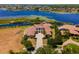 Aerial view of grand home with tile roof, circular driveway, and manicured landscaping at 14645 Isleview Dr, Winter Garden, FL 34787