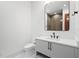 Bathroom featuring a white vanity with black hardware, toilet, and a shower behind glass at 14645 Isleview Dr, Winter Garden, FL 34787
