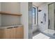 Modern bathroom features a glass enclosed shower with gray tiling and a built in storage cabinet with a wooden shelf above at 14645 Isleview Dr, Winter Garden, FL 34787