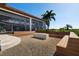 Outdoor fire pit area with built-in seating and lush tropical landscaping at 14645 Isleview Dr, Winter Garden, FL 34787