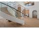 Bright foyer with a curved staircase, glass railings, and stylish wood accents at 14645 Isleview Dr, Winter Garden, FL 34787
