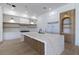 Bright kitchen with white cabinets, wood shelving, marble island, and stainless steel appliances at 14645 Isleview Dr, Winter Garden, FL 34787