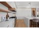 Well-lit kitchen with white cabinets, marble countertops, stainless steel appliances, and wood shelving at 14645 Isleview Dr, Winter Garden, FL 34787