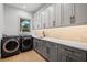 Spacious laundry room with front-load washer and dryer, ample storage cabinets, and sink area at 14645 Isleview Dr, Winter Garden, FL 34787