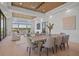 Open-concept living and dining area with expansive windows, coffered ceiling, and lake views at 14645 Isleview Dr, Winter Garden, FL 34787