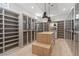 Spacious walk-in closet with custom shelving, glass-door cabinets and a center island with drawers and additional seating at 14645 Isleview Dr, Winter Garden, FL 34787
