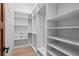 Bright walk-in closet with custom white shelves, drawers, and hanging rods for organized storage at 14645 Isleview Dr, Winter Garden, FL 34787
