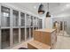 Large walk-in closet with custom shelving, glass-door cabinets and a center island with drawers and seating at 14645 Isleview Dr, Winter Garden, FL 34787