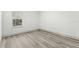 Neutral bedroom featuring wood-look floors, a large window, and white walls at 15369 Sw 60Th Cir, Ocala, FL 34473