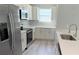 Bright kitchen with white cabinetry, stainless steel appliances, and quartz countertops at 15369 Sw 60Th Cir, Ocala, FL 34473