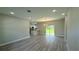 Spacious living room with light wood-look flooring and sliding glass doors to the backyard at 15369 Sw 60Th Cir, Ocala, FL 34473
